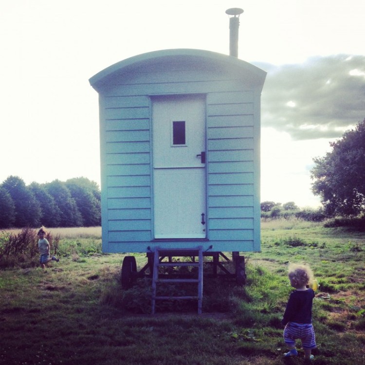 Children Running at The Rolling Downs two-children-running-around-a-shepherds-hut